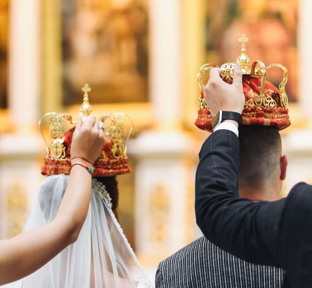 фрипик Bride and groom stand with crowns during the ceremony in church